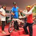 BERUNTUNG: Salah seorang peserta dari petugas DKP Surabaya mengambil hadiah sepeda gunung saat pengundian doorprize jalan sehat dan senam bersama dalam pembukaan SHS tahun 2015.